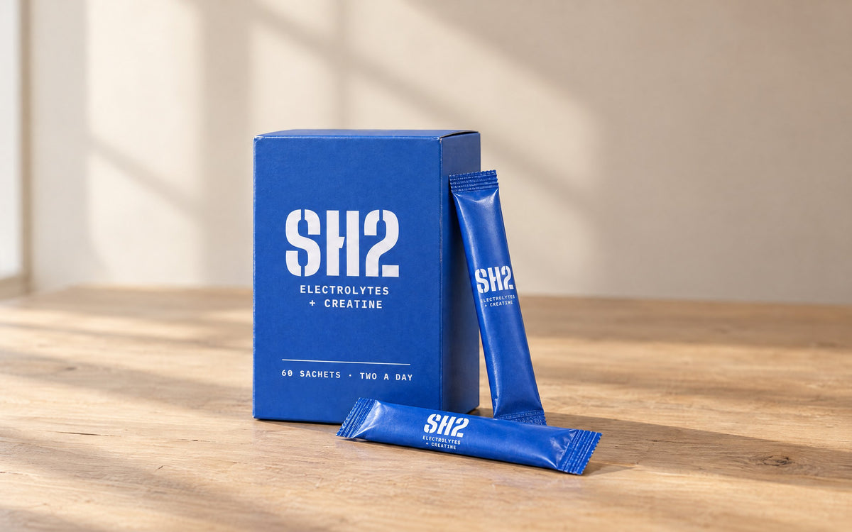 SH2 box and two sachets on an oak table in morning light