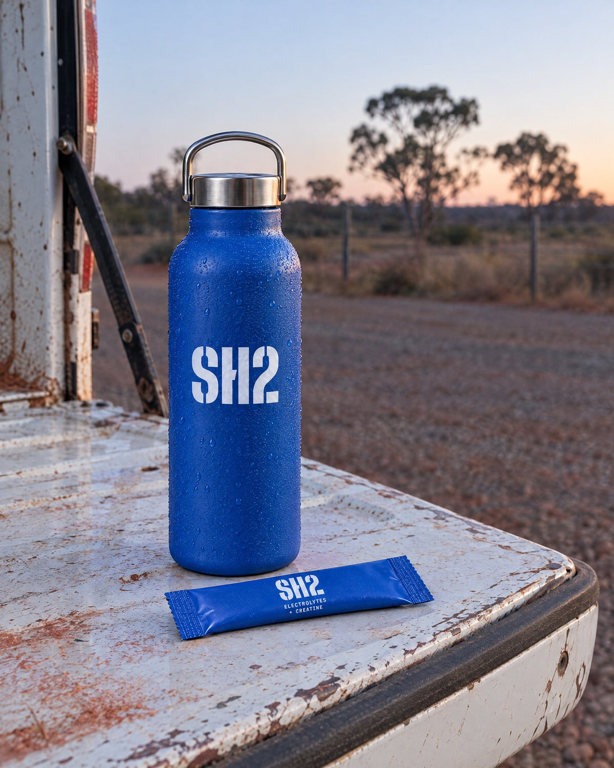 SH2 bottle and a sachet on a ute tailgate before sunrise